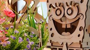 Wooden 3D display of a famous cartoon character standing beside a plant